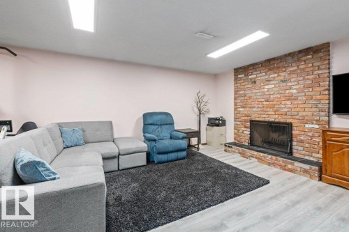 Living area featuring wood finished floors and a fireplace - 1 Larkspur Crescent, St. Albert, AB - Indoor With Fireplace