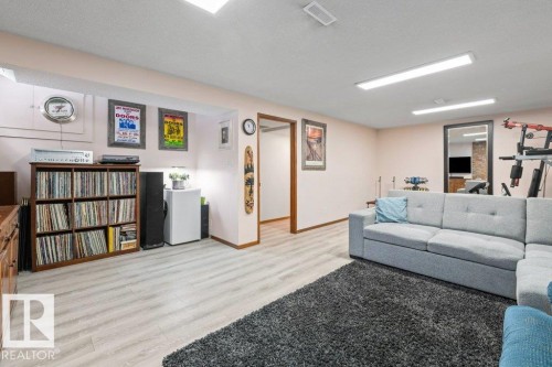 Living room featuring light wood finished floors and a textured ceiling - 1 Larkspur Crescent, St. Albert, AB - Indoor