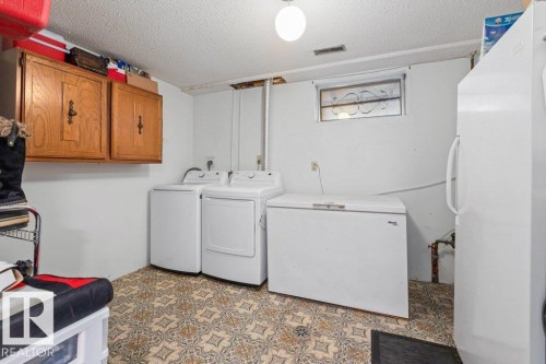 Laundry room with washing machine and clothes dryer, a textured ceiling, cabinet space, and light floors - 1 Larkspur Crescent, St. Albert, AB - Indoor Photo Showing Laundry Room