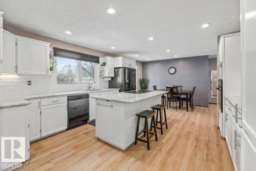 Kitchen featuring a center island, recessed lighting, white cabinets, black appliances, and light wood-type flooring - 1 Larkspur Crescent, St. Albert, AB - Indoor Photo Showing Kitchen With Upgraded Kitchen