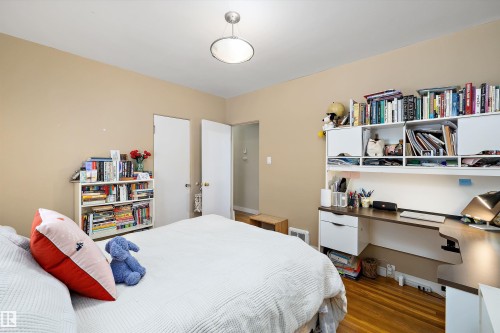 Bedroom with dark wood-style flooring and a desk - 11242 72 Avenue, Edmonton, AB - Indoor Photo Showing Bedroom