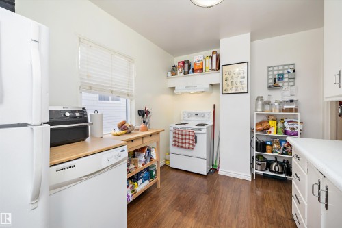 Kitchen featuring white appliances, light countertops, dark wood-style floors, and white cabinetry - 11242 72 Avenue, Edmonton, AB - Indoor Photo Showing Kitchen