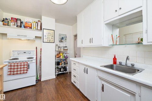 Kitchen with white electric stove, light countertops, and white cabinetry - 11242 72 Avenue, Edmonton, AB - Indoor Photo Showing Kitchen