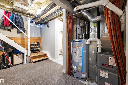 Unfinished basement with water heater, carpet flooring, and heating unit - 11242 72 Avenue, Edmonton, AB - Indoor Photo Showing Basement