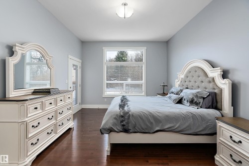 Bedroom featuring dark wood-type flooring and baseboards - 1409 Westerra Bay, Stony Plain, AB - Indoor Photo Showing Bedroom
