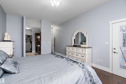 Bedroom with a walk in closet, dark wood finished floors, and ensuite bath - 1409 Westerra Bay, Stony Plain, AB - Indoor Photo Showing Bedroom