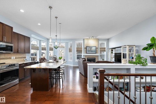 Kitchen featuring appliances with stainless steel finishes, dark brown cabinets, a kitchen breakfast bar, open floor plan, and recessed lighting - 1409 Westerra Bay, Stony Plain, AB - Indoor Photo Showing Kitchen With Upgraded Kitchen