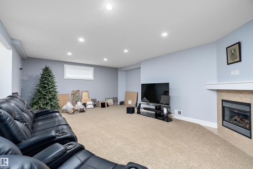 Living room with recessed lighting, carpet, and a tile fireplace - 1409 Westerra Bay, Stony Plain, AB - Indoor With Fireplace