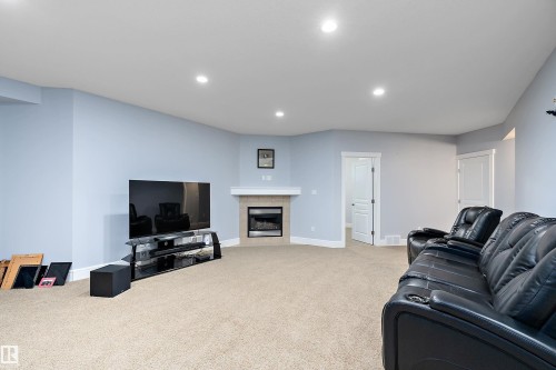 Living area featuring a tiled fireplace, recessed lighting, and light colored carpet - 1409 Westerra Bay, Stony Plain, AB - Indoor