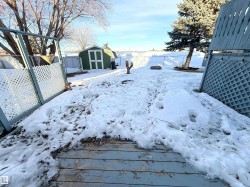 Yard covered in snow with a fenced backyard and a storage shed - 