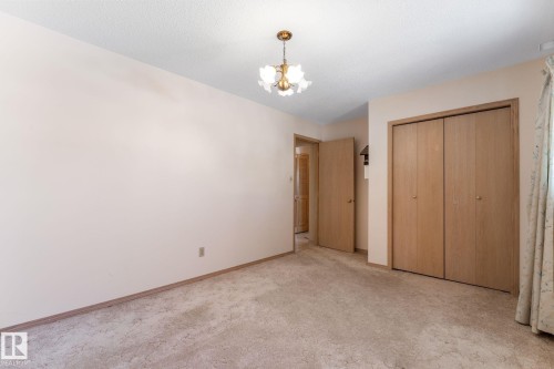 Unfurnished bedroom featuring a chandelier, carpet flooring, and a closet - 3519 111B Street, Edmonton, AB - Indoor Photo Showing Other Room