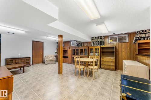 Dining space featuring wood walls and a textured ceiling - 3519 111B Street, Edmonton, AB - Indoor