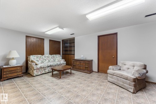 Living area with a textured ceiling and light tile patterned floors - 3519 111B Street, Edmonton, AB - Indoor
