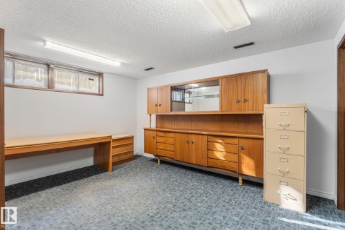Office area with dark colored carpet and a textured ceiling - 3519 111B Street, Edmonton, AB - Indoor