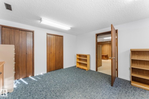 Unfurnished bedroom featuring multiple closets, a textured ceiling, and carpet floors - 3519 111B Street, Edmonton, AB - Indoor