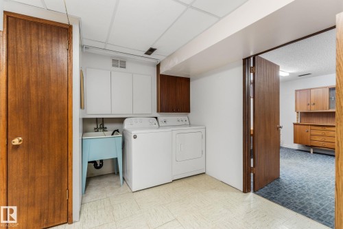 Laundry area with light flooring, cabinet space, and independent washer and dryer - 3519 111B Street, Edmonton, AB - Indoor Photo Showing Laundry Room