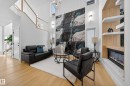 Living area with a glass covered fireplace, a high ceiling, and light wood finished floors - 9907 68 Street, Edmonton, AB  - Indoor Photo Showing Living Room With Fireplace 
