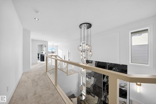 Corridor with an upstairs landing, light colored carpet, and hanging lights - 9907 68 Street, Edmonton, AB - Indoor Photo Showing Other Room