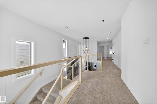 Hallway with an upstairs landing, carpet flooring, and a chandelier - 9907 68 Street, Edmonton, AB - Indoor Photo Showing Other Room