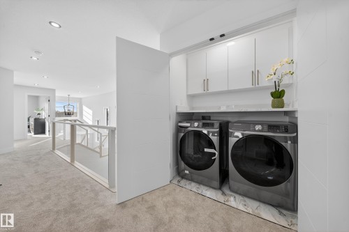 Laundry area with cabinet space, light colored carpet, washer and dryer, and recessed lighting - 9907 68 Street, Edmonton, AB - Indoor Photo Showing Laundry Room