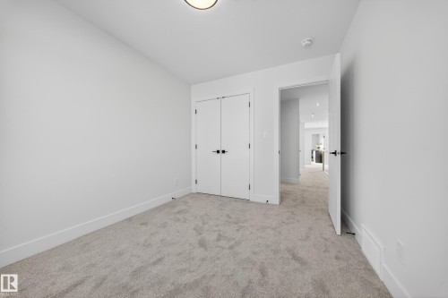 Unfurnished bedroom featuring light carpet and a closet - 9907 68 Street, Edmonton, AB - Indoor Photo Showing Other Room