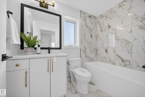 Bathroom with vanity, washtub / shower combination, and light marble finish floors - 9907 68 Street, Edmonton, AB - Indoor Photo Showing Bathroom