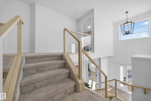 Stairs featuring healthy amount of natural light and hanging lights - 9907 68 Street, Edmonton, AB - Indoor Photo Showing Other Room
