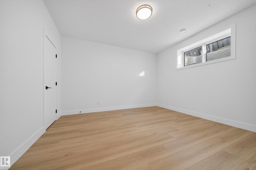 Unfurnished room with light wood-style flooring - 9907 68 Street, Edmonton, AB - Indoor Photo Showing Other Room