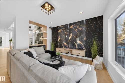 Living area featuring an accent wall, recessed lighting, light wood-style floors, and wallpapered walls - 9907 68 Street, Edmonton, AB - Indoor