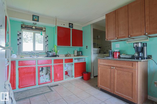 Kitchen with freestanding refrigerator, light countertops, dual tone cabinets, washer / dryer, and light tile patterned floors - 19 Ridgeway Drive Nw, Edmonton, AB - Indoor Photo Showing Kitchen