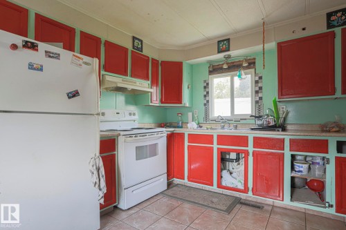 Kitchen with white appliances, red cabinets, light countertops, ornamental molding, and light tile patterned floors - 19 Ridgeway Drive Nw, Edmonton, AB - Indoor Photo Showing Kitchen
