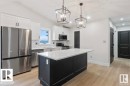 Kitchen with stainless steel appliances, white cabinetry, hanging light fixtures, dark cabinets, and a kitchen island - 1432 Wildrye Crescent, Cold Lake, AB  - Indoor Photo Showing Kitchen With Upgraded Kitchen 