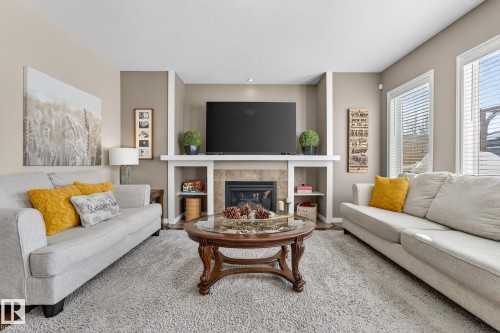 Living room with a tile fireplace and baseboards - 1734 63A Street, Edmonton, AB - Indoor Photo Showing Living Room With Fireplace