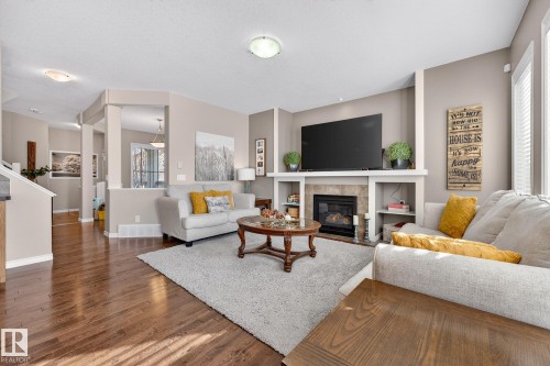 Living area with a tile fireplace and dark wood-type flooring - 1734 63A Street, Edmonton, AB - Indoor Photo Showing Living Room With Fireplace