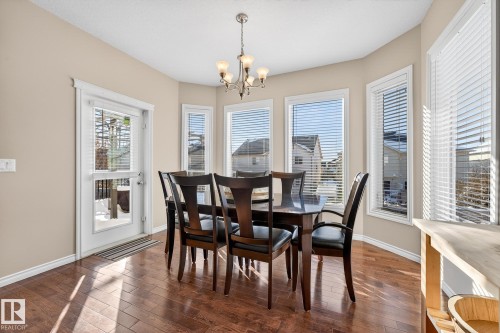 Dining room with dark wood-style floors and a chandelier - 1734 63A Street, Edmonton, AB - Indoor Photo Showing Dining Room