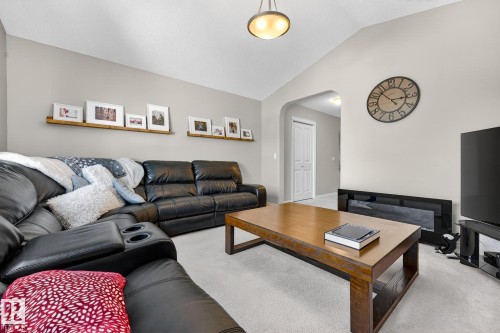 Living area featuring arched walkways, light colored carpet, and lofted ceiling - 1734 63A Street, Edmonton, AB - Indoor Photo Showing Living Room