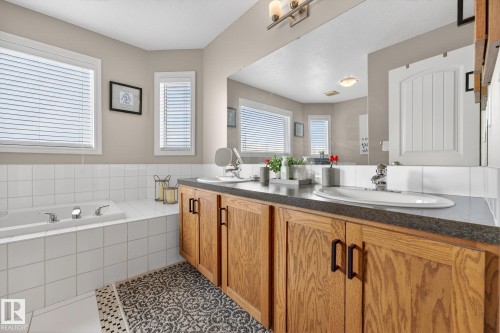 Bathroom featuring double vanity, a bath, plenty of natural light, and tile patterned flooring - 1734 63A Street, Edmonton, AB - Indoor Photo Showing Bathroom