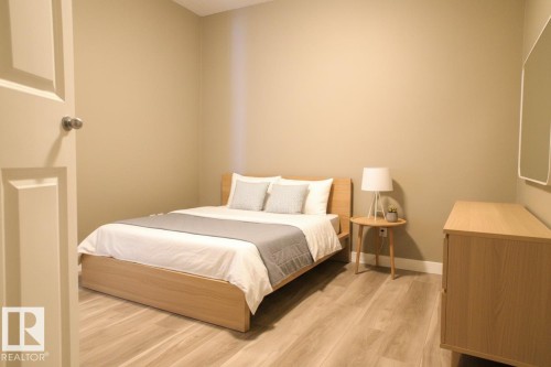 Bedroom featuring light wood-style flooring and baseboards - 104 5804 Place Nw, Edmonton, AB - Indoor Photo Showing Bedroom