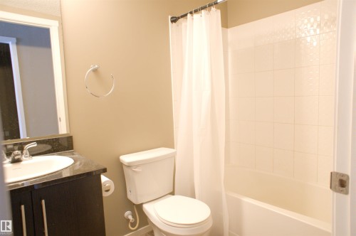 Bathroom featuring vanity and shower / tub combo with curtain - 104 5804 Place Nw, Edmonton, AB - Indoor Photo Showing Bathroom