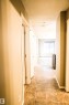 Hallway with a textured ceiling and baseboards - 104 5804 Place Nw, Edmonton, AB  - Indoor Photo Showing Other Room 