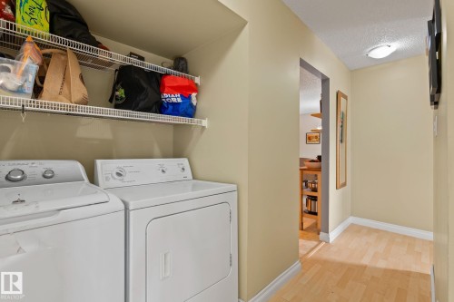 Laundry area featuring a textured ceiling, washing machine and dryer, and light wood-style floors - 1925 Saddleback Road, Edmonton, AB - Indoor Photo Showing Laundry Room