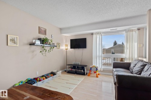 Living area featuring wood finished floors and a textured ceiling - 1925 Saddleback Road, Edmonton, AB - Indoor Photo Showing Living Room