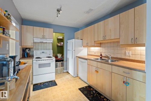 Kitchen featuring light wood finish cabinets, white appliances, light floors, open shelves, and light countertops - 1925 Saddleback Road, Edmonton, AB - Indoor Photo Showing Kitchen With Double Sink