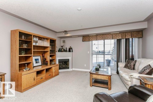 325 7801 Golf Course Road, Stony Plain, AB - Indoor Photo Showing Living Room With Fireplace