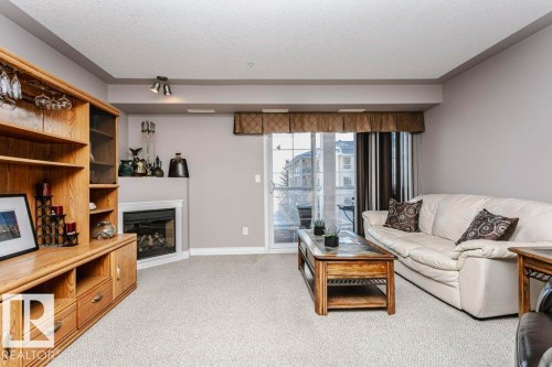 325 7801 Golf Course Road, Stony Plain, AB - Indoor Photo Showing Living Room With Fireplace