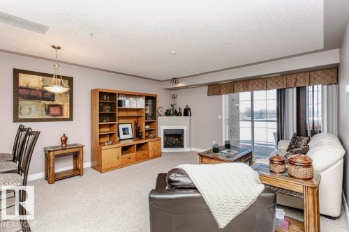325 7801 Golf Course Road, Stony Plain, AB - Indoor Photo Showing Living Room With Fireplace