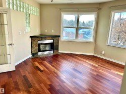 Unfurnished living room featuring a tiled fireplace and hardwood / wood-style floors - 