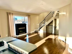 Living area with stairway, hardwood / wood-style floors, a fireplace, and recessed lighting - 