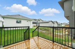 Wooden deck featuring a lawn and a residential view - 