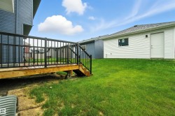 View of grassy yard with a deck and stairway - 